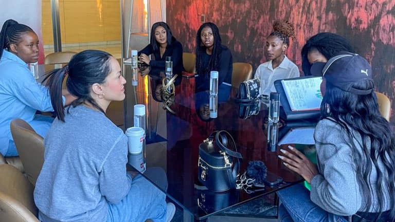 Diverse group of women in law looking at a world map and discussing strategy.